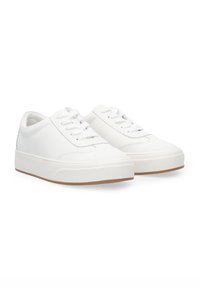 Weiße Sneaker aus einem glatten Material mit runder Zehenform, flachen Schnürsenkeln und einer kontrastierenden braunen Gummisohle. Minimalistischer Stil.
