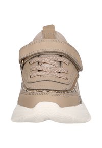 Baskets de sport beiges avec une tige texturée, des lacets élastiques et une sangle Velcro. Dotées d'une semelle en caoutchouc blanche avec un motif de tread en zigzag.