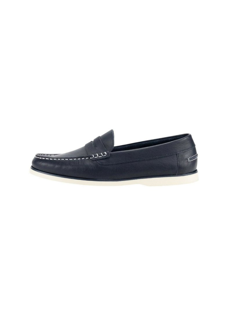 Mocasines de cuero de color marino con costuras y suela blanca. Diseño bajo, textura suave, sin logotipos visibles. Punta redondeada y estilo sin cordones.