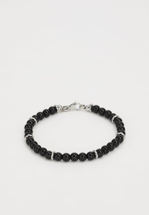 Náramok z čiernych korálikov s lesklými čiernymi korálikmi, prerušovaný striebornými akcentmi a kovovou sponou. Guľatý a hladký povrch.