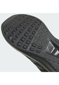 Czarna podeszwa zewnętrzna buta sportowego z teksturowanym wzorem zapewniającym przyczepność, wyposażona w niebrudzącą podeszwę oraz detal z logo marki po boku.