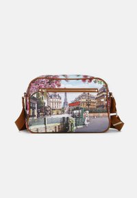 Borsa rettangolare con una scena parigina stampata sul tessuto, caratterizzata da fiori di ciliegio rosa, una tracolla marrone e una cerniera dorata.