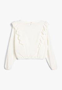 Weiße, verkürzte Bluse mit langen Ärmeln, die entlang der Vorder- und Rückseite Rüschenakzente aufweist, aus strukturiertem Stoff besteht und einen Knopfverschluss am Hals hat.