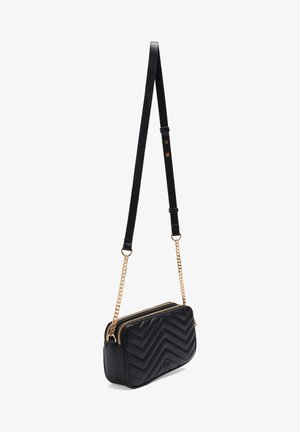 Zwarte, doorgestikte rechthoekige crossbodytas met gouden ketting en verstelbare zwarte riem, met twee ritssluitvakken.