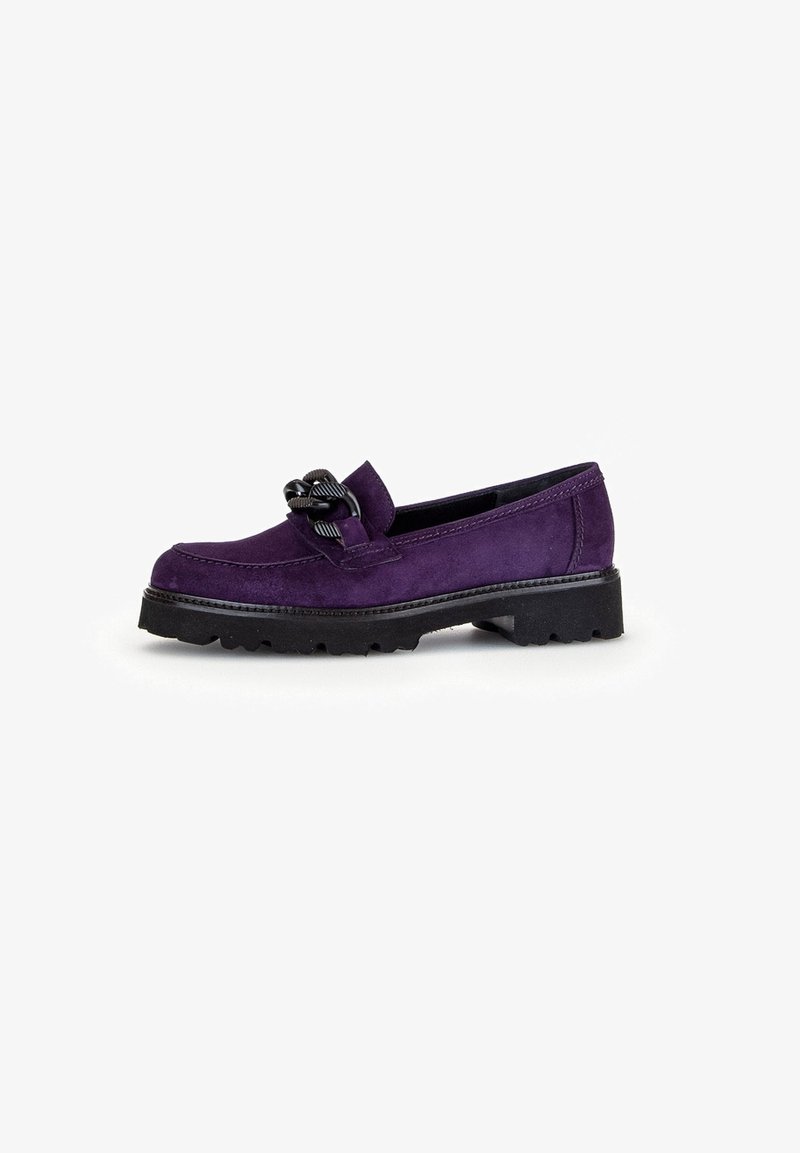 Paarse suede instapper met een ronde neus, voorzien van een decoratieve zwarte knoop aan de voorkant en een robuuste zwarte rubberen zool.