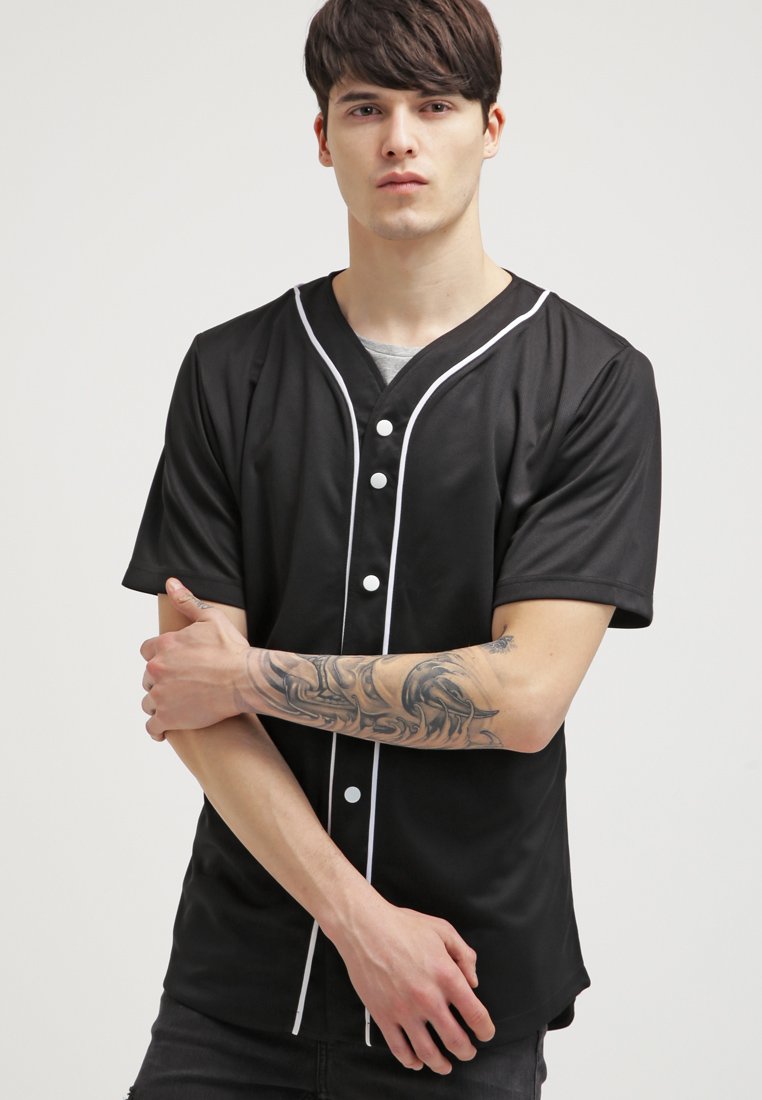 T-shirt noir à manches courtes avec des passepoils blancs et une patte de boutonnage. Fabriqué en tissu lisse et léger. Présente une coupe décontractée et des textures variées.