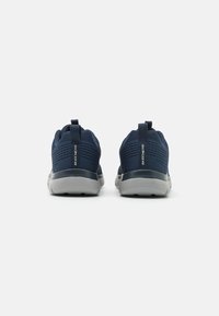 Navy sneakers with mesh fabric upper, grey sole, rear pull tab, and textured detailing on the sides. Stable and breathable design.