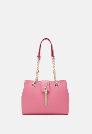 Bolso de mano rosa con un acabado brillante, asas de cadena dorada, un acento de logo en forma de V y un adorno de borlas adjunto al cierre frontal.