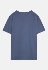 T-shirt s krátkym rukávom z mäkkej modrej látky. Má okrúhy výstrih, voľný strih a ploché švy bez ďalších dizajnových prvkov.
