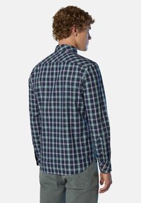 Vista posteriore di una camicia da uomo a maniche lunghe con un motivo a quadri blu navy e verde, realizzata in tessuto morbido con polsini e colletto abbottonati.
