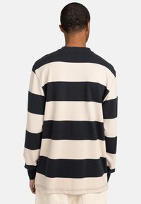 Langsleeve gestreepte shirt met afwisselende marineblauwe en crèmekleurige horizontale strepen, een ronde hals en een ontspannen pasvorm. Katoenmix stof.
