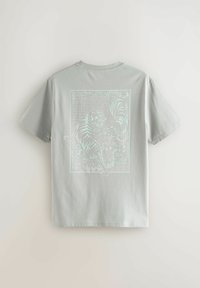 Hellgraues Baumwoll-T-Shirt mit einem großen weißen Grafikdruck von zwei Tigern vor einem gemusterten Hintergrund auf der Rückseite. Rundhalsausschnitt, kurze Ärmel.