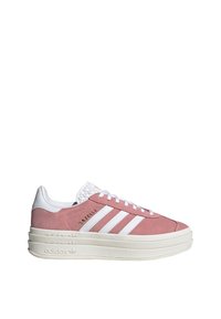 Zapatillas Adidas Gazelle en color rosa con franjas blancas, suela gruesa blanca, cordones en la parte delantera y logo de Adidas en relieve en la suela.