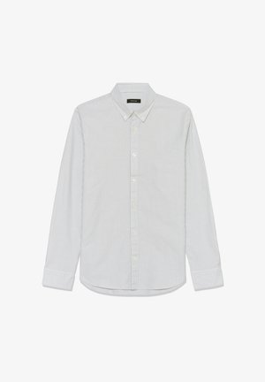 Balta krekla ar garām piedurknēm ar gaiši ziliem vertikāliem svītrām, pogu aizdari apkaklē, krūšu kabatu un izliektu apakšmalu. Kokvilnas auduma tekstūra.