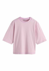 T-shirt surdimensionné à manches courtes en coton rose clair avec un col rond et des coutures visibles autour des bords, présenté sur un fond blanc.