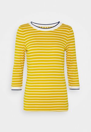 Camisa de manga larga a rayas amarillas con rayas horizontales en blanco y azul marino. Presenta un cuello redondo, mangas de tres cuartos y puños en contraste.