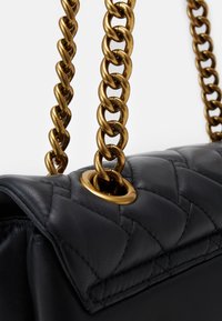 Borsa a tracolla in pelle nera con motivo trapuntato, dettagli in oro con una tracolla a catena e particolare con omini circolari.