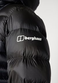 Crna puf jakna s kvadratnim uzorkom i sjajnom teksturom, s istaknutim bijelim "berghaus" logotipom na rukavu.