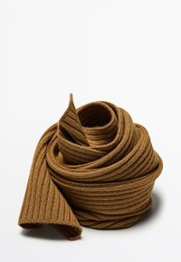 Brun ribbad stickad tyg rullad till en tight spiral, som har en mjuk textur och en slät yta. Kanterna är något krullade.