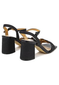 Sandali neri con tacco, caratterizzati da una superficie texture, un tacco a blocco largo, cinturini incrociati e chiusura con fibbia regolabile.