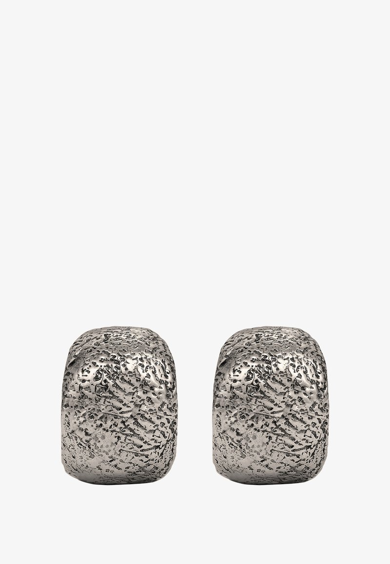 Silverfärgade metallbokstöd med en texturerad, oregelbunden yta och rundade kanter, som har en polerad yta och en modern design.