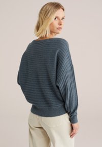 Dicker, gerippter Strickpullover in einem dunkelblau-grauen Farbton mit lässiger Passform, weitem Bootsausschnitt und voluminösen Ärmeln.