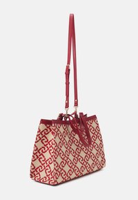 Sac fourre-tout rouge et beige en toile avec motif géométrique, doté de deux poignées solides et d'une sangle d'épaule amovible et réglable.
