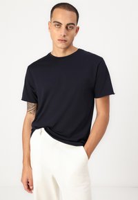 Navy blue short-sleeve t-shirt made from soft, stretchy cotton. Crew neck design with a relaxed fit and slightly rolled cuffs.