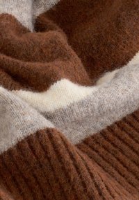 Tessuto a maglia a righe marroni e crema con una texture morbida e pelosa, che mostra una combinazione di sezioni coste e lisce.