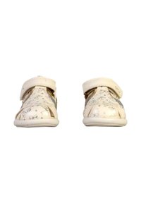 Zapatos blancos con un patrón floral, diseño de punta abierta, correa ajustable y suela de color claro. El material parece suave con texturas sutiles.