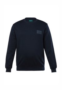 Sweatshirt bleu marine à col rond avec des poignets côtelés, tissu texturé et une patch sur la poitrine avec un logo. Design simple et décontracté.