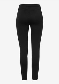 Pantalon noir slim-fit à taille haute et tissu texturé, vu de dos sur un fond blanc uni.