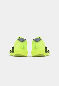 Lime green athletic shoes featuring a sleek design, black accents, and a textured heel, with a grey collar and a flexible sole.