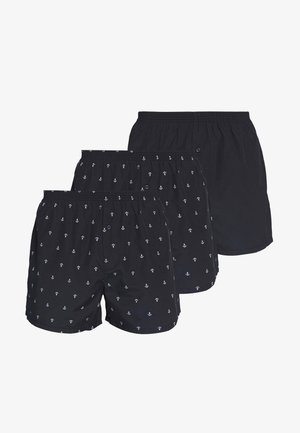 Czarne szorty bokserskie w biały wzór kotwic, z elastycznym paskiem w talii i detalem w postaci guzika. Wyeksponowane trzy pary, wszystkie o podobnym wzorze.