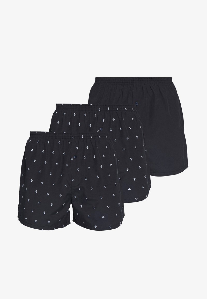 Boxer corto neri con motivo di ancore bianche, vita elastica e dettaglio dei bottoni. Tre paia in esposizione, tutti con design simile.