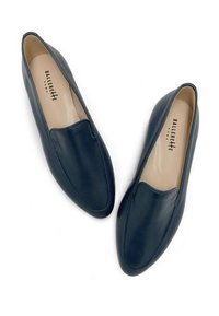 Mocassini in pelle blu navy con una texture liscia, punta arrotondata e design slip-on. L'interno presenta una fodera di colore chiaro; logo visibile.