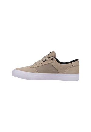 Beige suede sneaker with a white rubber sole, round toe, black accent on the collar, and lace-up closure. Features a canvas side panel.