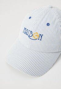 Stripet blå og hvid kasket med broderet "MAIBON" logo i blå og gul. Fremstillet af stof, med en buet skygge og justerbar rem.