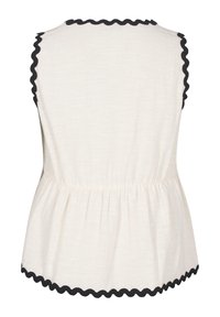 Světlobéžový peplum top s vroubkovaným černým lemem kolem výstřihu a dolního okraje, disponující uvolněným střihem a nařaseným pasem pro přidanou texturu.