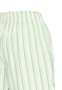 Tissu blanc avec des rayures verticales vertes et une taille élastique, montrant une partie d'un vêtement, probablement un pantalon ou un short.