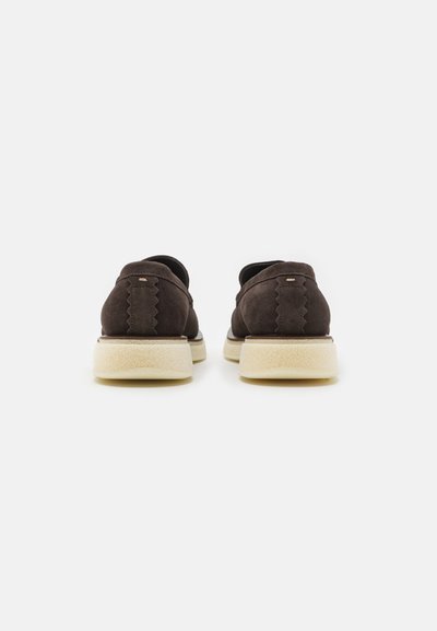Pantofi din suede maro cu un design ondulat la spate, având o talpă flexibilă de culoare deschisă și detalii minime de cusătură.