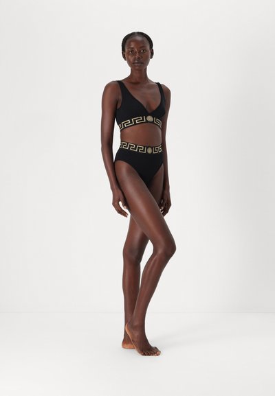 Schwarzes Bikini-Set mit V-Ausschnitt-Oberteil und hochgeschnittenem Unterteil, verziert mit goldfarbenem griechischem Schlüssel-Muster am Bund. Glatte Textur.