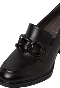 Mocassin en cuir noir avec une grosse chaîne noire décorative traversant le dessus et un petit talon carré, taille 37 visible à l'intérieur.