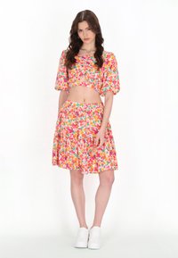 Virágmintás crop top és szoknya szett, sokszínű árnyalatokban, puffos ujjakkal, kulcskáttöréssel és tiered fodros, bővülő szoknyával.