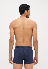 Navy blue boxer briefs with a geometric pattern, featuring a smooth waistband, snug fit, and soft fabric texture. Designed for comfort.