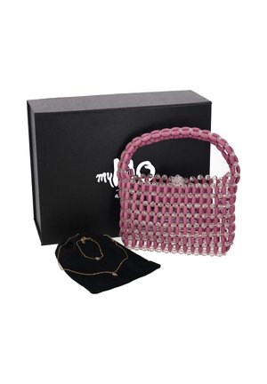 Bolso rosa con cuentas transparentes, caja de regalo negra y un collar de oro sobre una funda negra sobre fondo blanco.