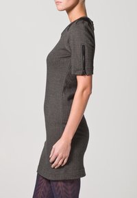 Černé šaty s herringbone vzorem, krátké rukávy a postranní zip. Lehce přiléhavý silueta s kulatým výstřihem a hladkou texturou.