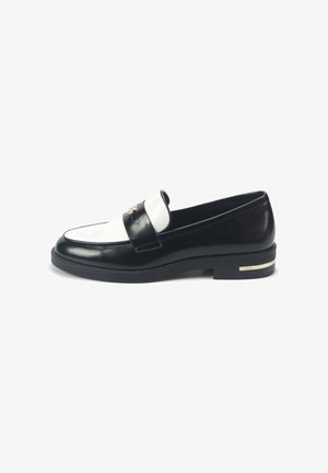 Black and white leather loafer with a glossy finish, featuring a rounded toe, gold hardware accent, and a low black heel.