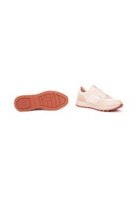 Zapatilla color beige claro con acentos en durazno, un zapato en posición vertical mostrando los cordones, el otro con la suela hacia arriba exhibiendo una suela de durazno con relieve y patrón.