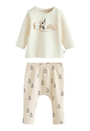 Cream long-sleeve top with food-themed appliqués; elastic waistband pants with cow print. Soft cotton fabric, relaxed fit for comfort.
